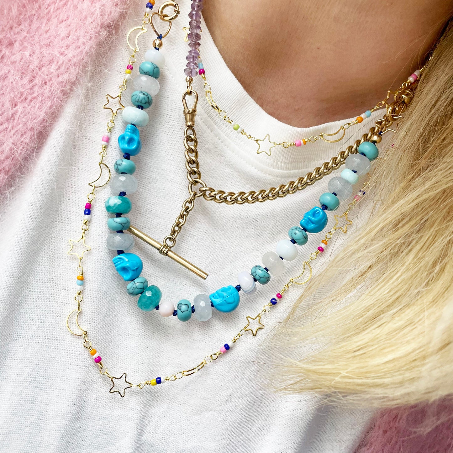 woman wearing layering necklace with enamel colour star moon
